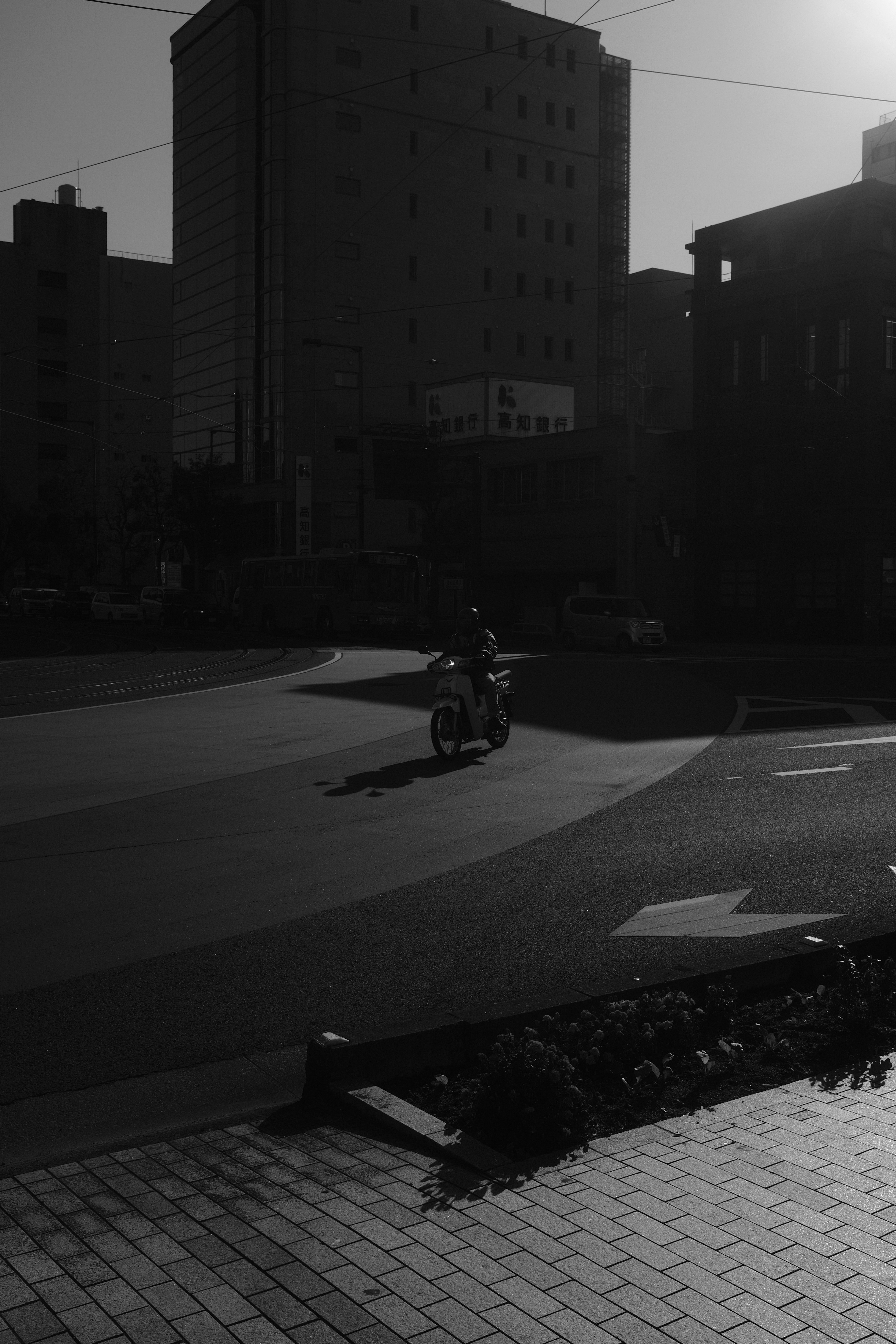 grayscale photo of man riding motorcycle on road